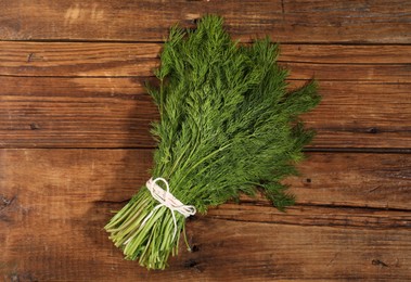 Bunch of fresh green dill on wooden table, top view