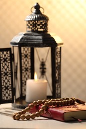 Arabic lantern, Quran and misbaha on white table