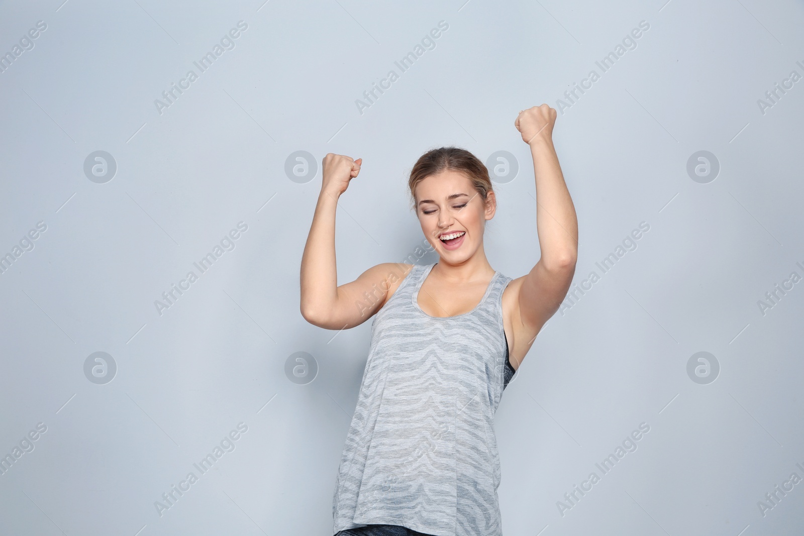 Photo of Happy young woman celebrating victory on color background