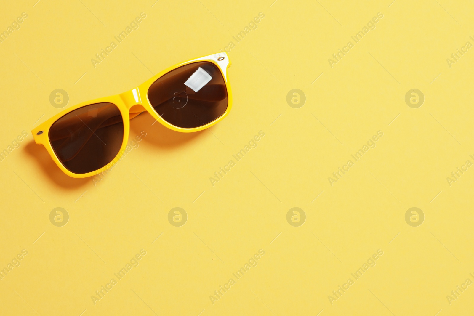 Photo of Stylish sunglasses on color background, top view with space for text. Beach accessories