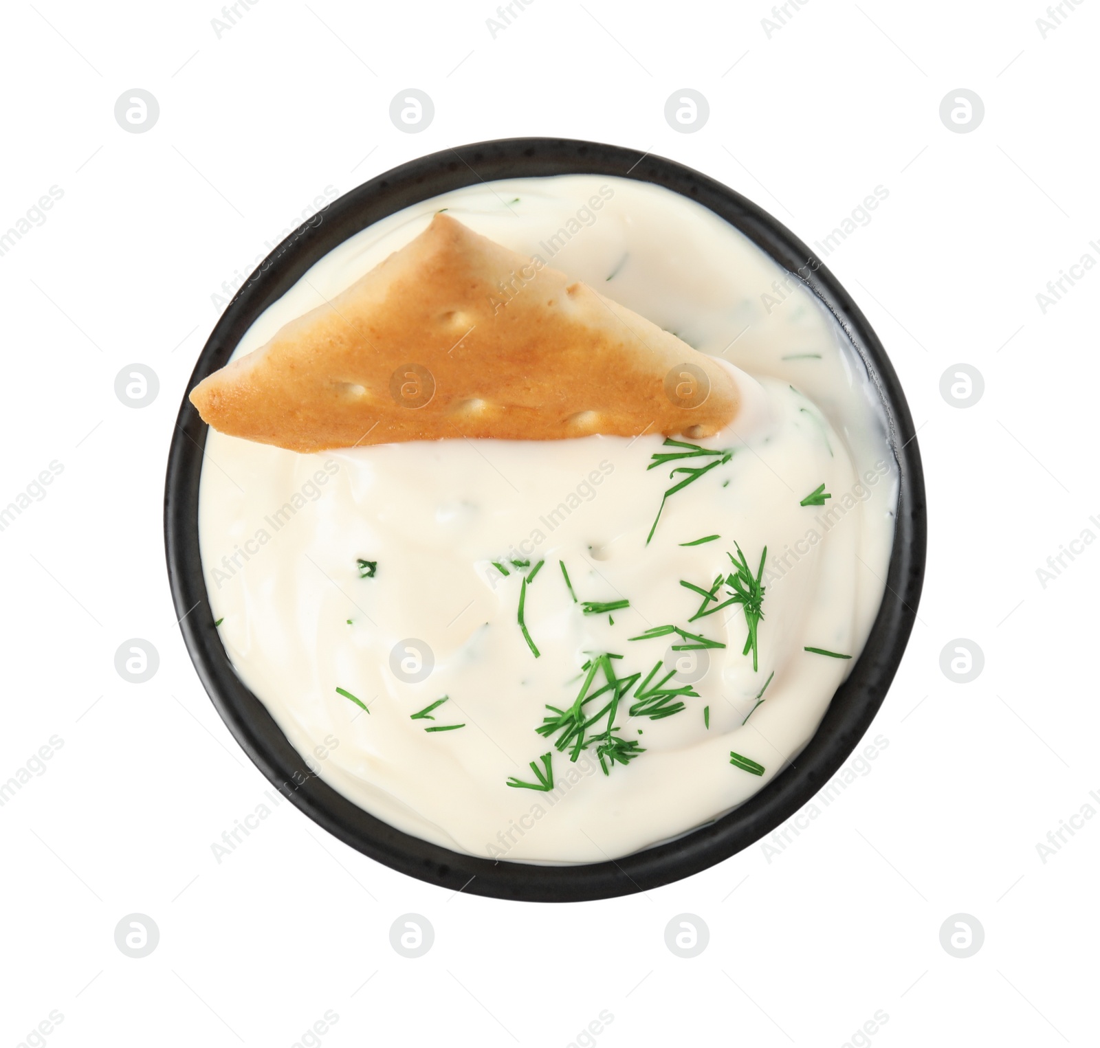 Photo of Tasty creamy dill sauce with cracker in bowl isolated on white, top view