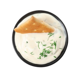 Photo of Tasty creamy dill sauce with cracker in bowl isolated on white, top view