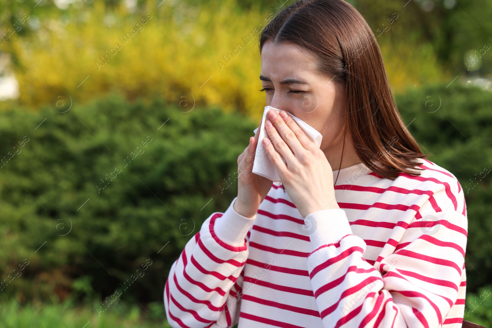 Photo of Woman with napkin suffering from seasonal allergy outdoors