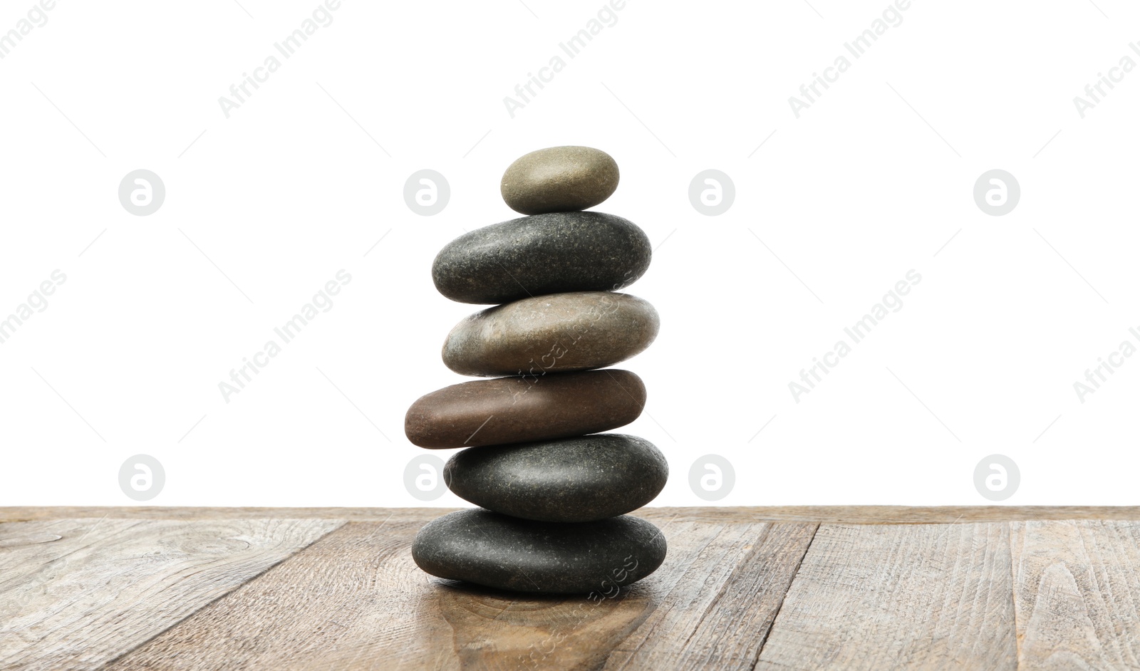 Photo of Stack of spa stones on wooden table against white background