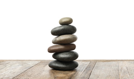 Stack of spa stones on wooden table against white background