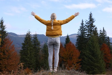 Photo of Happy woman in peaceful mountains, back view. Feeling freedom