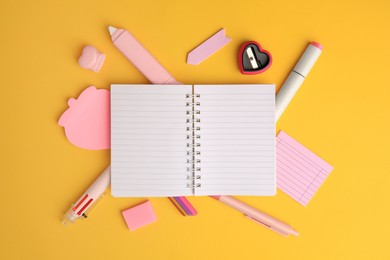 Photo of Flat lay composition with open notebook and different school stationery on yellow background, space for text. Back to school