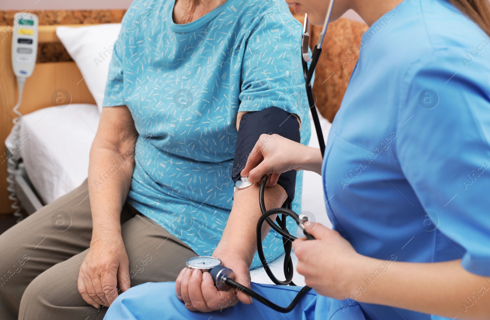 Photo of Nurse measuring senior woman's blood pressure in hospital ward, closeup. Medical assisting