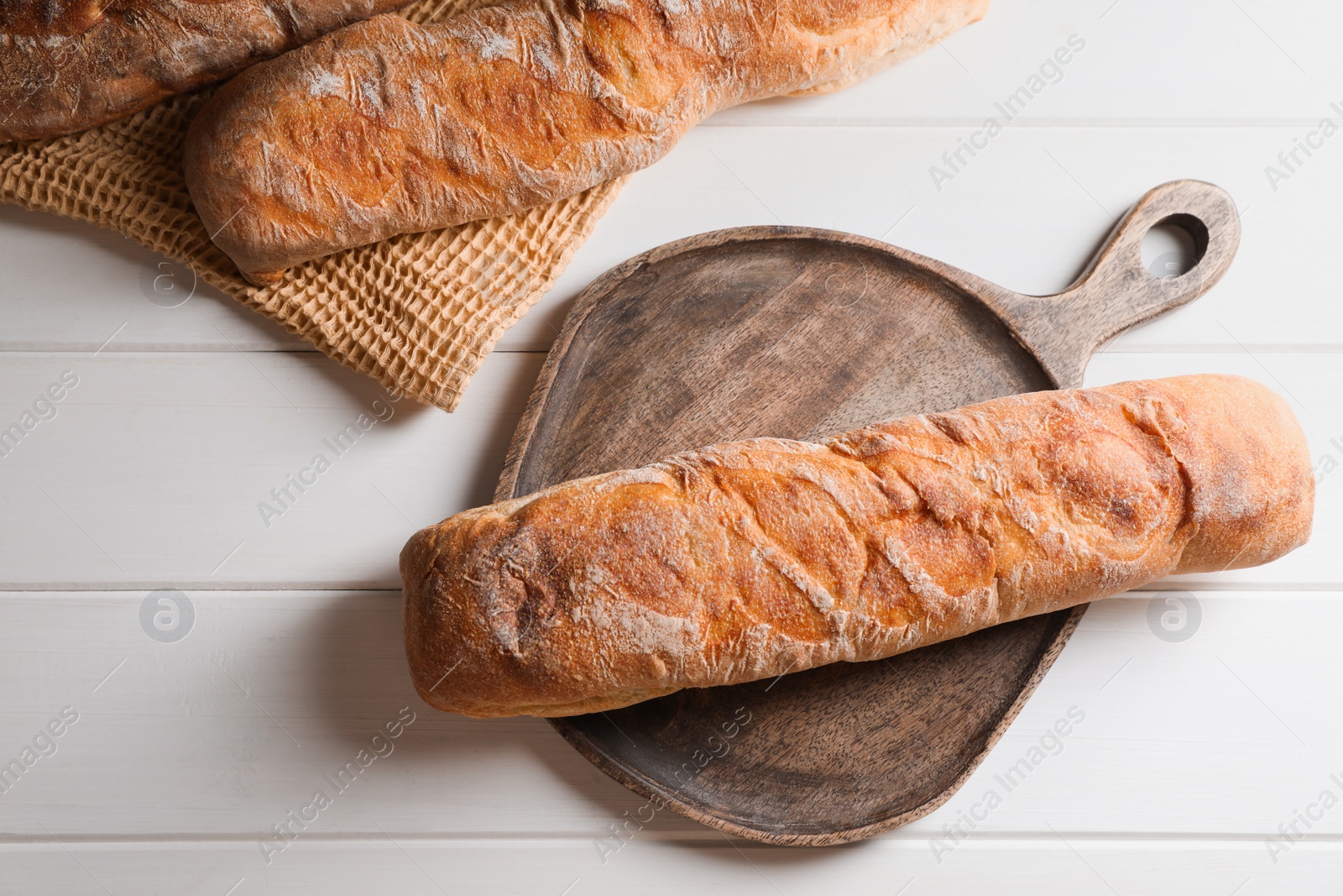 Photo of Fresh crispy ciabattas on white wooden table, flat lay