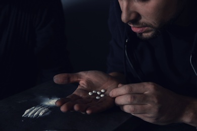 Photo of Young addicted man taking drugs, focus on hands
