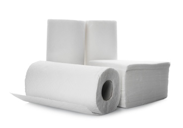 Photo of Rolls and stack of clean paper tissues on white background