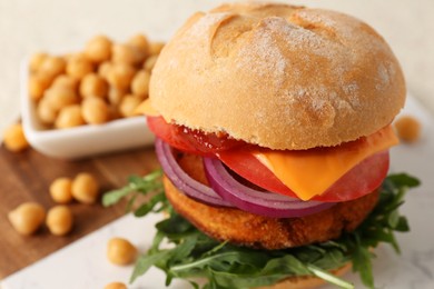 Photo of Tasty vegetarian burger with chickpea cutlet on white table, closeup