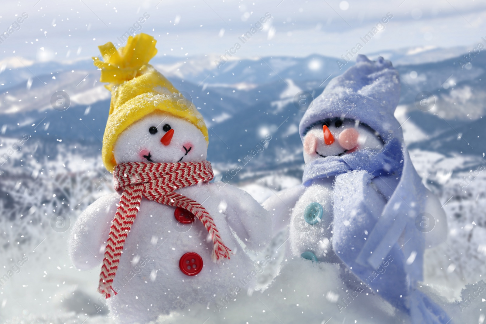 Image of Cute small decorative snowmen outdoors on sunny day