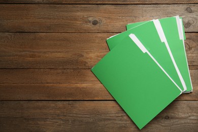 Light green files with documents on wooden table, top view. Space for text