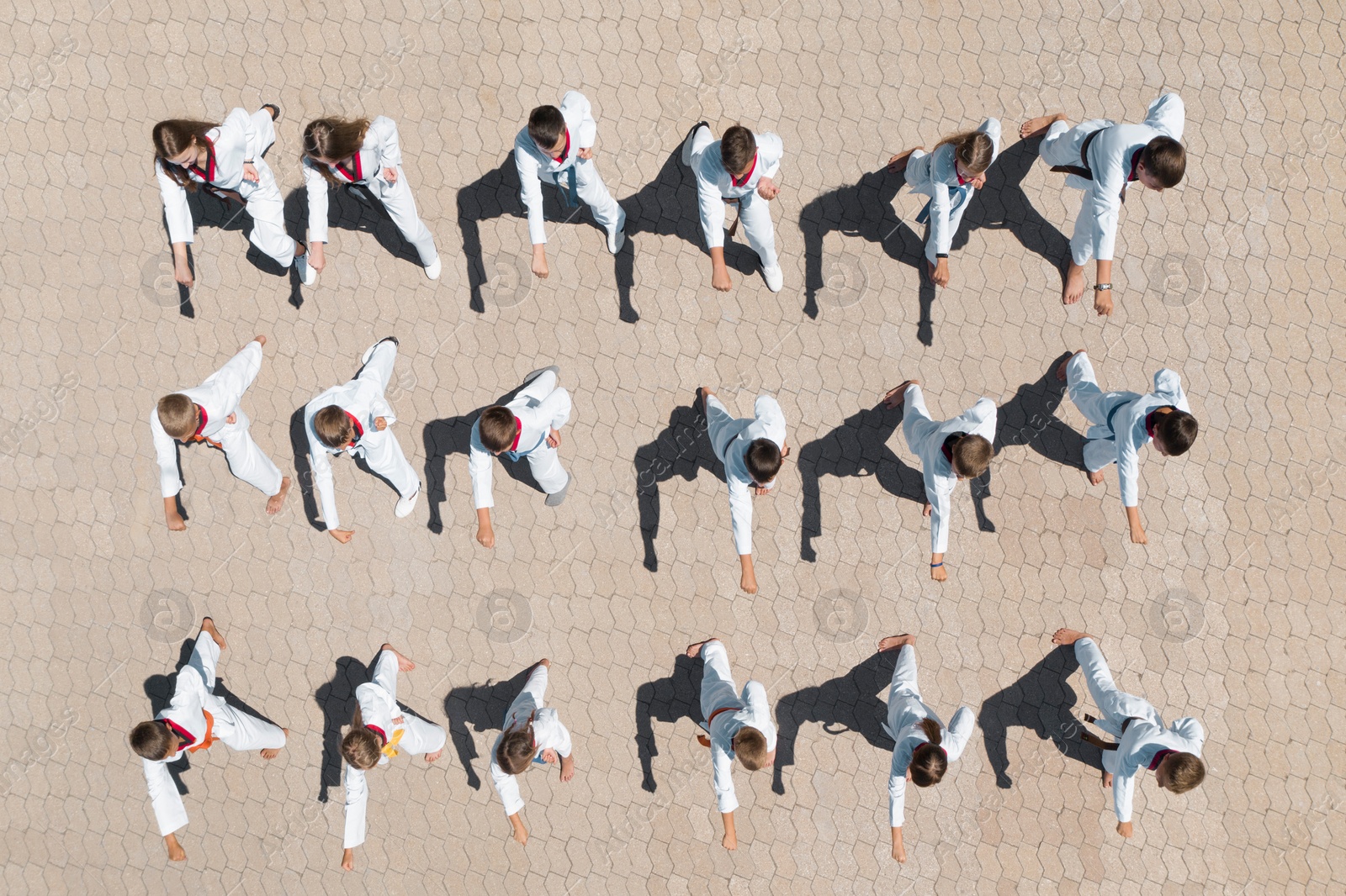 Image of OCHAKIV, UKRAINE - JULY 09, 2020: Children in kimono practicing karate outdoors, aerial top view. Spending time in summer camp "Sportium"