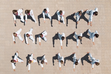 OCHAKIV, UKRAINE - JULY 09, 2020: Children in kimono practicing karate outdoors, aerial top view. Spending time in summer camp "Sportium"