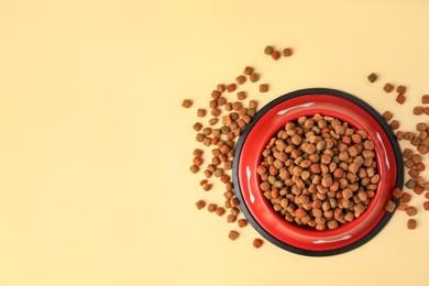 Photo of Dry dog food and feeding bowl on beige background, flat lay. Space for text