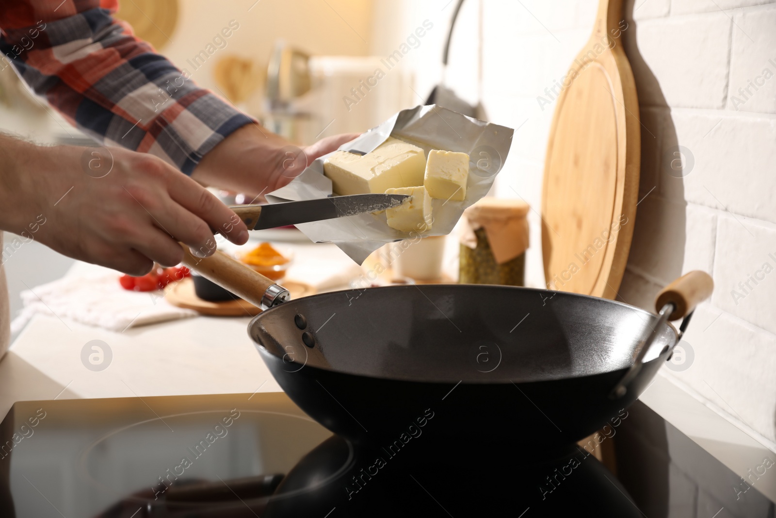 Photo of Man putting butter into frying pan, closeup