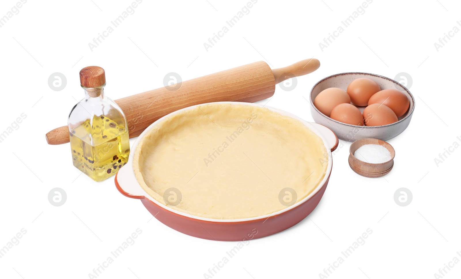 Photo of Pie tin with fresh dough, rolling pin and ingredients isolated on white. Making quiche
