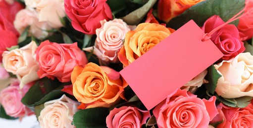 Bouquet of beautiful roses with blank card, top view. Banner design