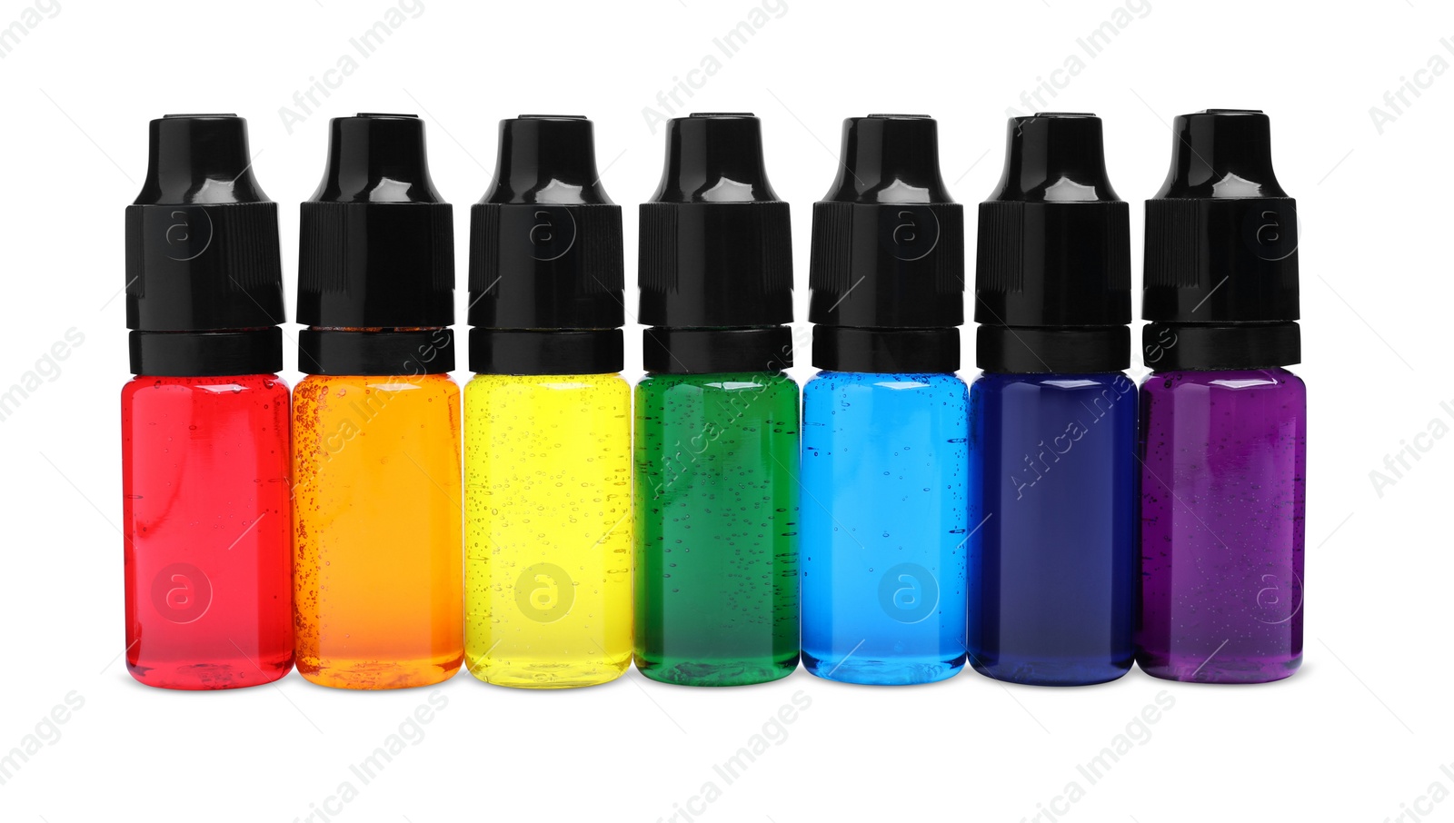 Photo of Bottles with different food coloring on white background