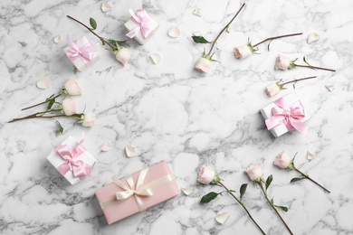 Photo of Flat lay composition with beautiful roses and gift boxes on marble background. Space for text