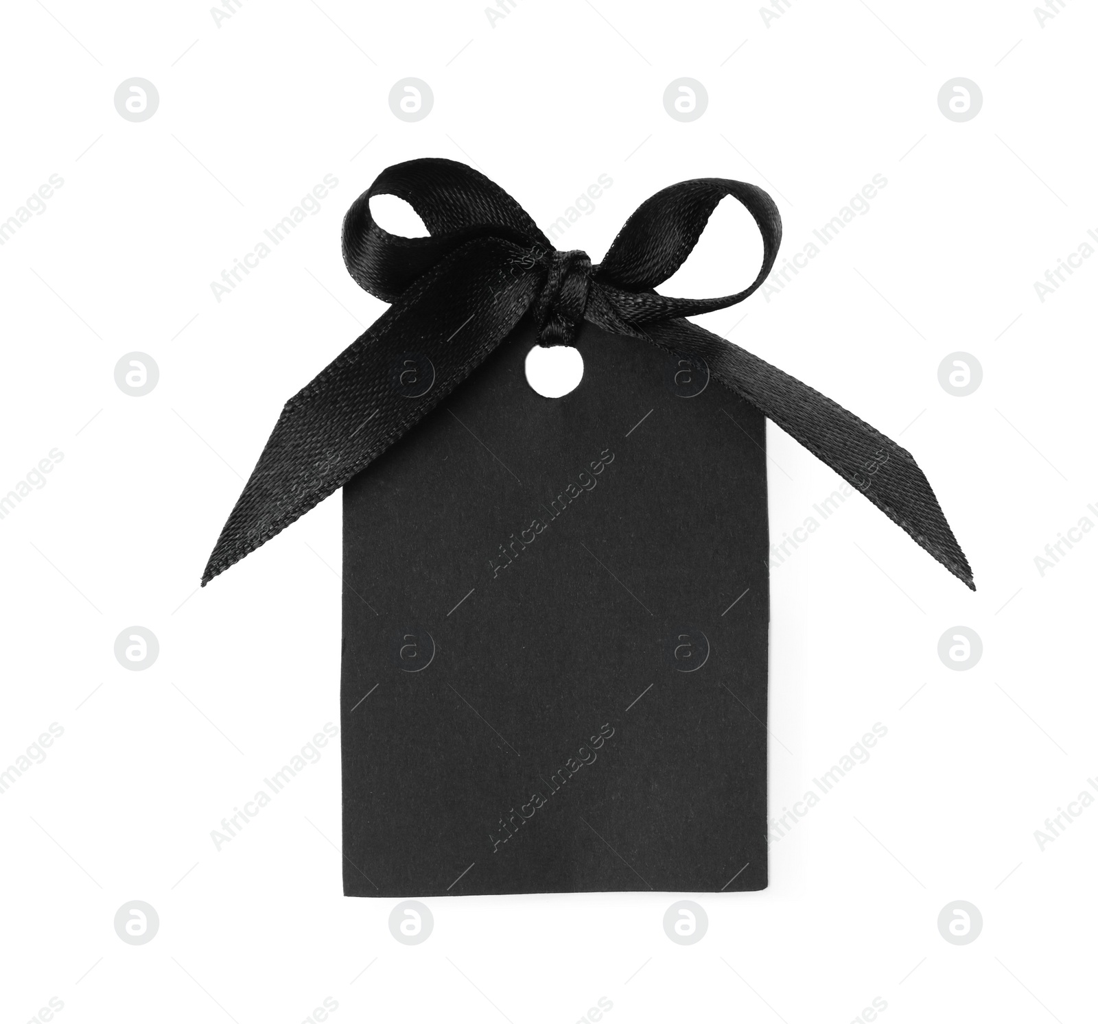 Photo of Blank tag with black satin ribbon tied in bow on white background, top view. Space for design