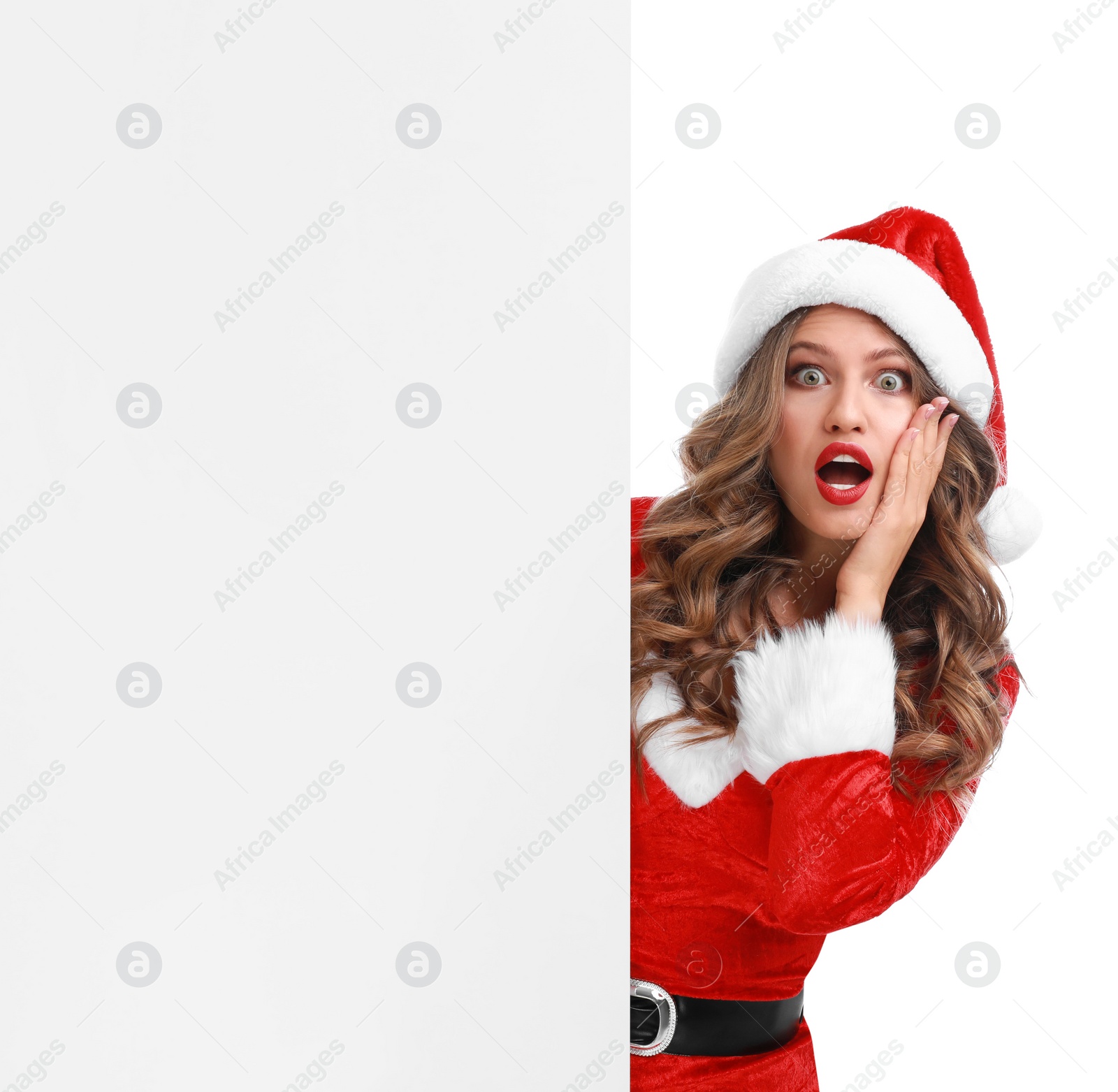 Photo of Beautiful Santa girl peeping out of blank banner on white background. Christmas celebration