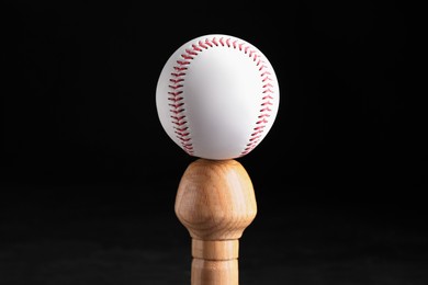 Photo of Baseball bat and ball on black background. Sports equipment