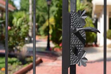 Photo of Beautiful metal gate handle and lock outdoors on sunny day, closeup