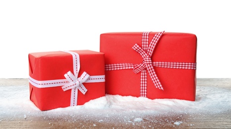 Photo of Christmas gift boxes and snow on table against white background