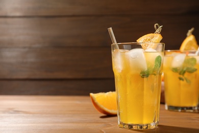 Delicious orange soda water on wooden table. Space for text