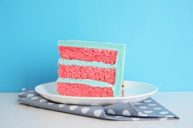 Slice of fresh delicious birthday cake on table against color background