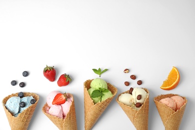 Photo of Composition with delicious ice creams in waffle cones on white background, top view
