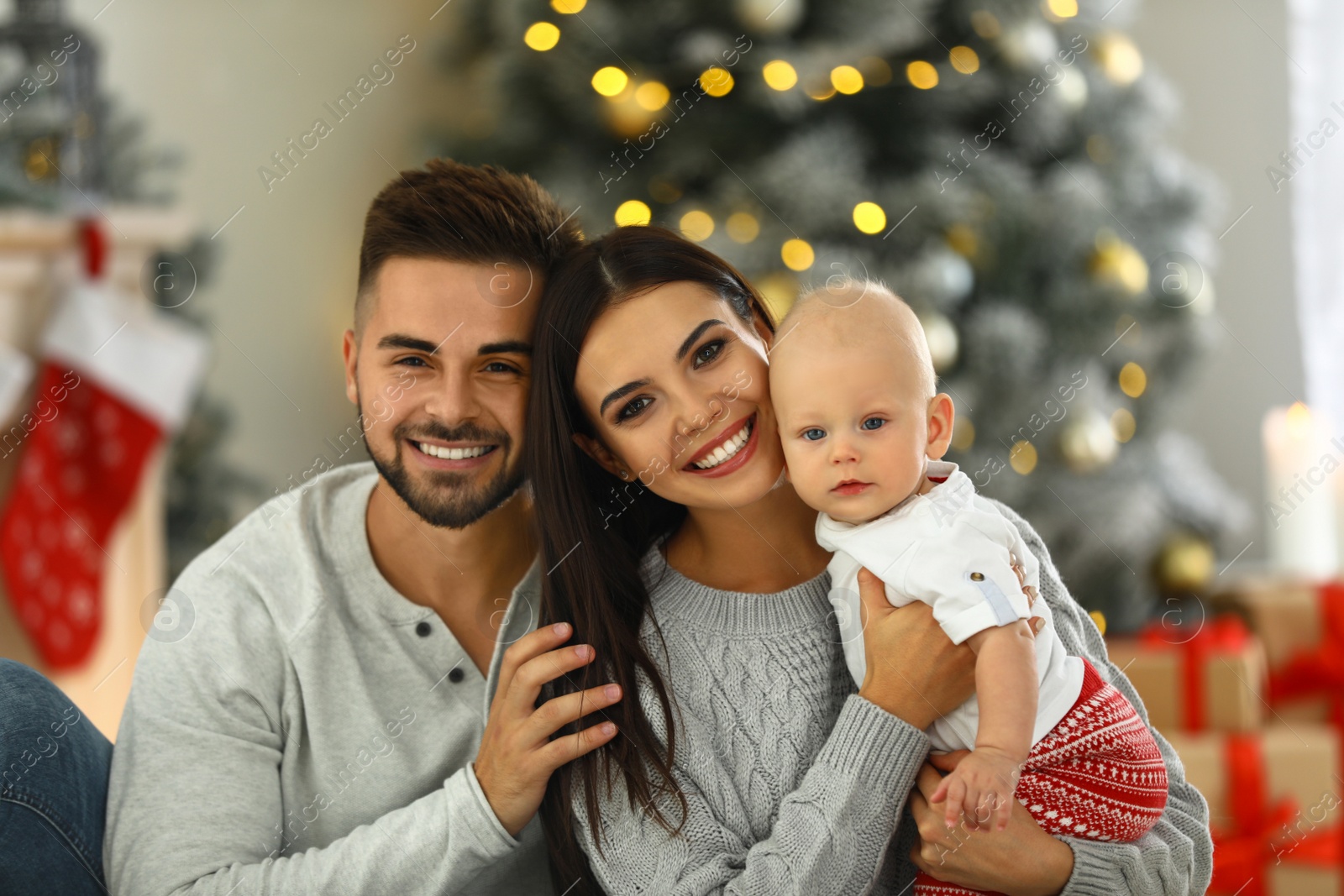 Photo of Happy family with cute baby at home. Christmas celebration