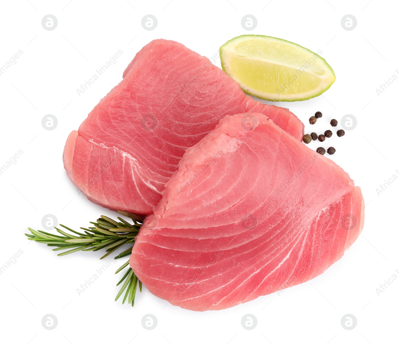 Photo of Fresh raw tuna fillets with peppercorns and lime wedge on white background, top view