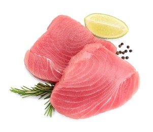 Fresh raw tuna fillets with peppercorns and lime wedge on white background, top view