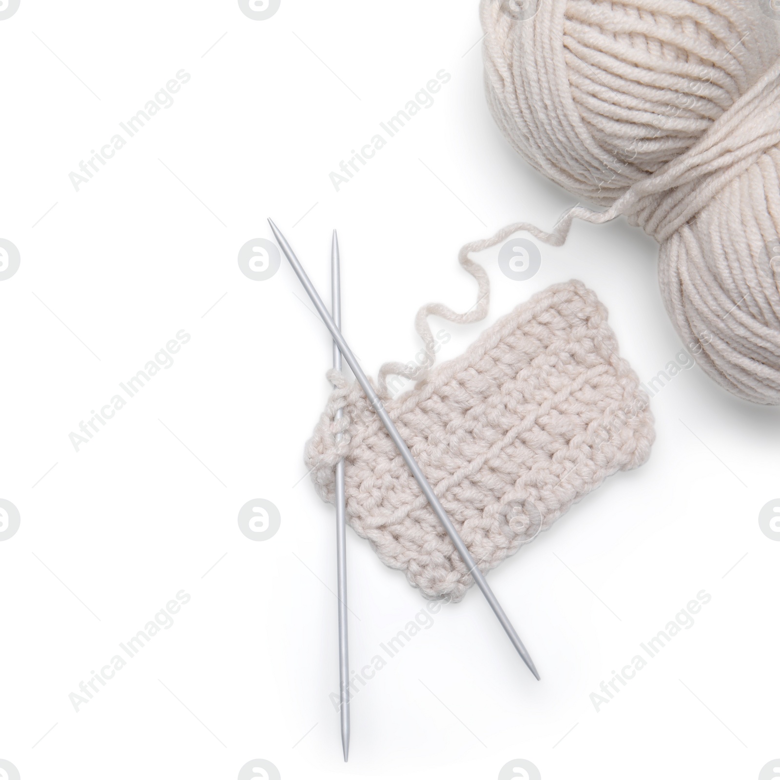 Photo of Soft woolen yarn, knitting and metal needles on white background, top view