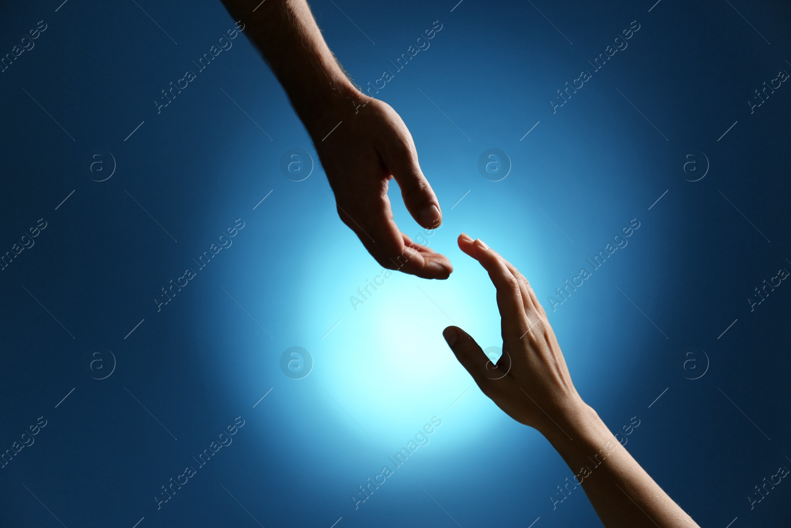 Photo of Man reaching for woman's hand on color background, closeup. Help and support concept