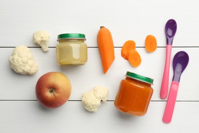 Flat lay composition with tasty baby food in jars and ingredients on white wooden table