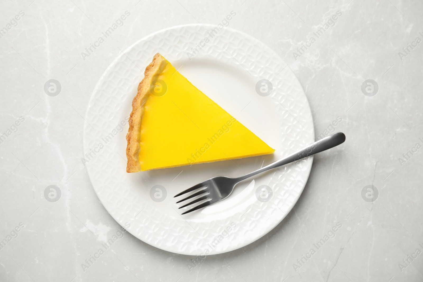 Photo of Delicious homemade lemon pie on light grey marble table, top view