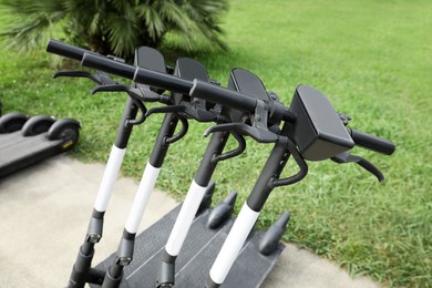 Photo of Row of electric scooters outdoors, closeup. Rental service