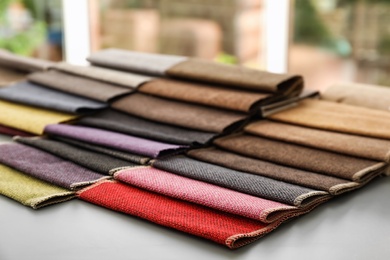 Photo of Fabric samples of different colors for interior design on table