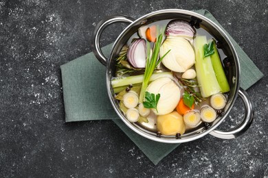 Different ingredients for cooking tasty bouillon in pot on black table, top view. Space for text