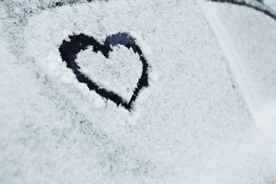 Photo of Heart drawn on car covered with snow, closeup. Space for text