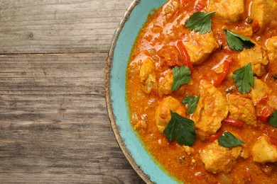 Delicious chicken curry on wooden table, top view. Space for text