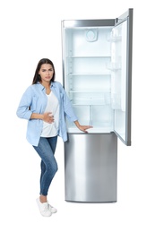 Photo of Hungry woman near empty refrigerator on white background