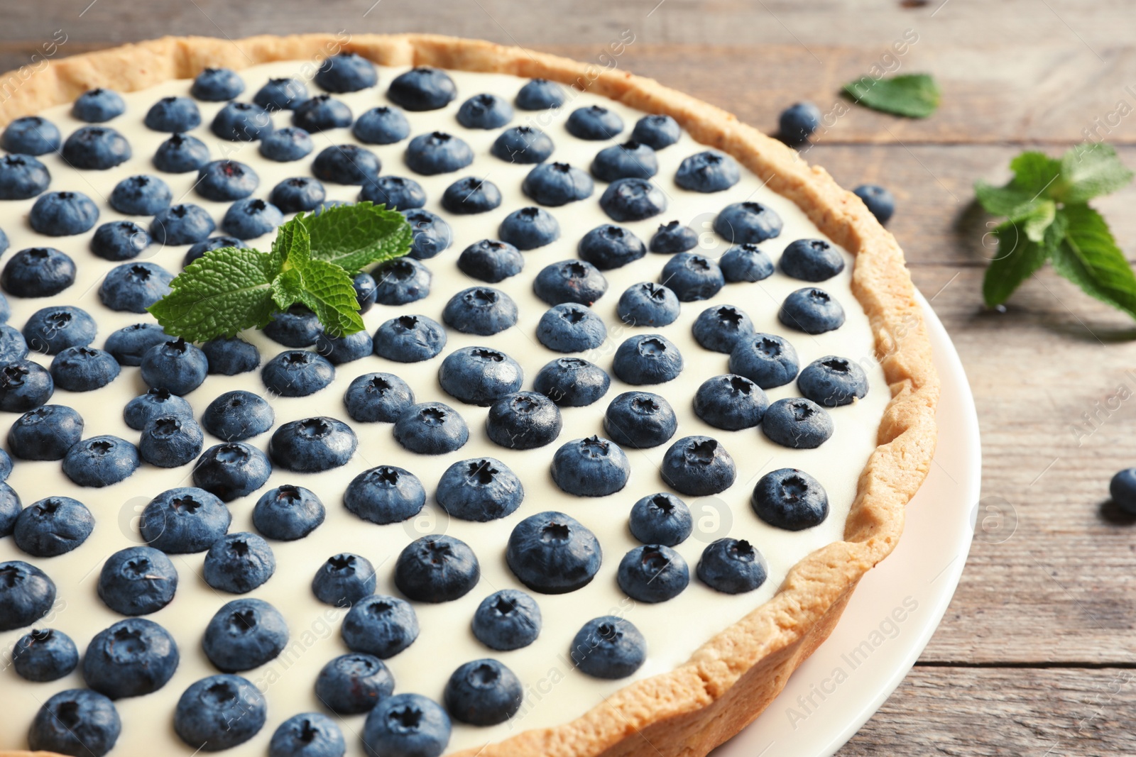 Photo of Tasty cake with blueberry on wooden table