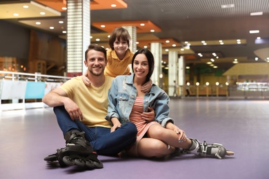 Happy family spending time at roller skating rink