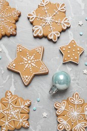 Photo of Tasty Christmas cookies and bauble on light grey marble table, flat lay